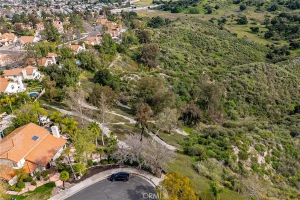 an aerial view of residential houses with outdoor space and trees