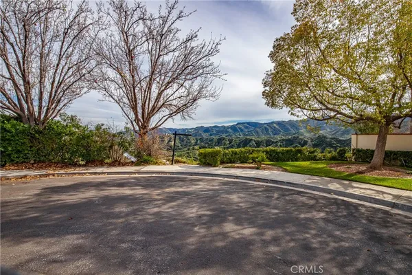 a view of a house with a big yard and large trees