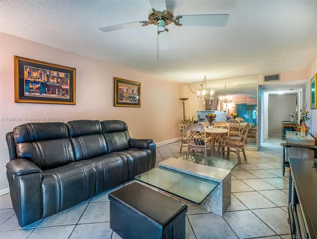 a living room with furniture a dining table and paintings on the wall