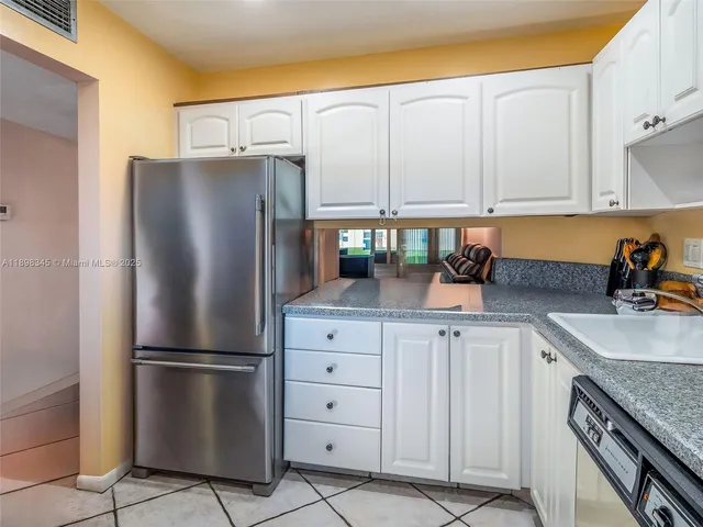 a kitchen with appliances a sink and cabinets
