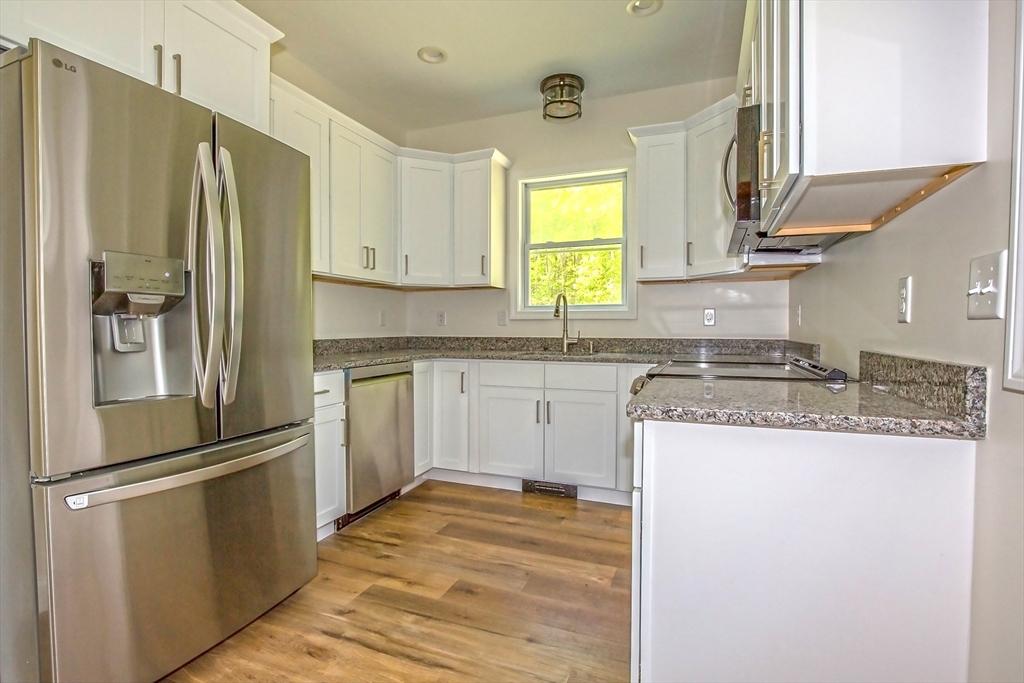 165 Sandisfield Road Sandisfield, MA 01255 - Photo 9 of 37 a kitchen with a refrigerator a sink and cabinets