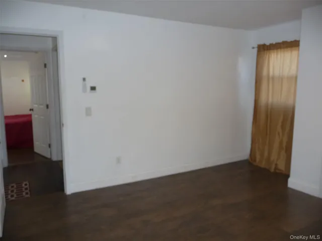 a view of empty room with wooden floor and fireplace