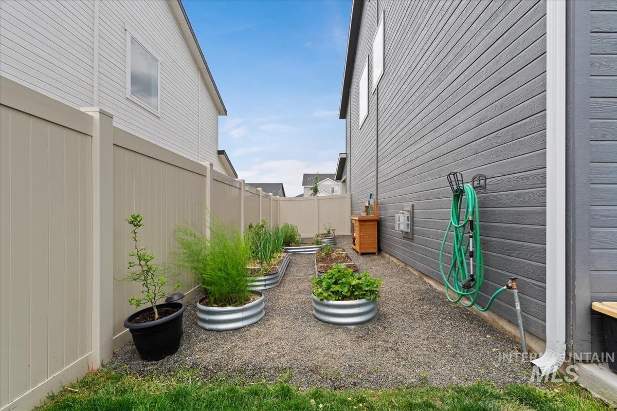 815 Knowledge Street Middleton, ID 83644 - Photo 39 of 49 Side yard featuring gravel ground cover, a series of galvanized metal raised garden beds with established plants