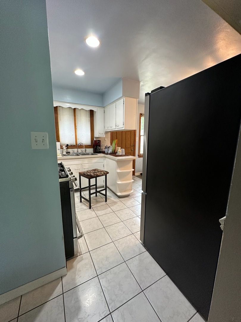 17871 Locust Street Lansing, IL 60438 - Photo 15 of 25 a kitchen with a refrigerator and a stove top oven