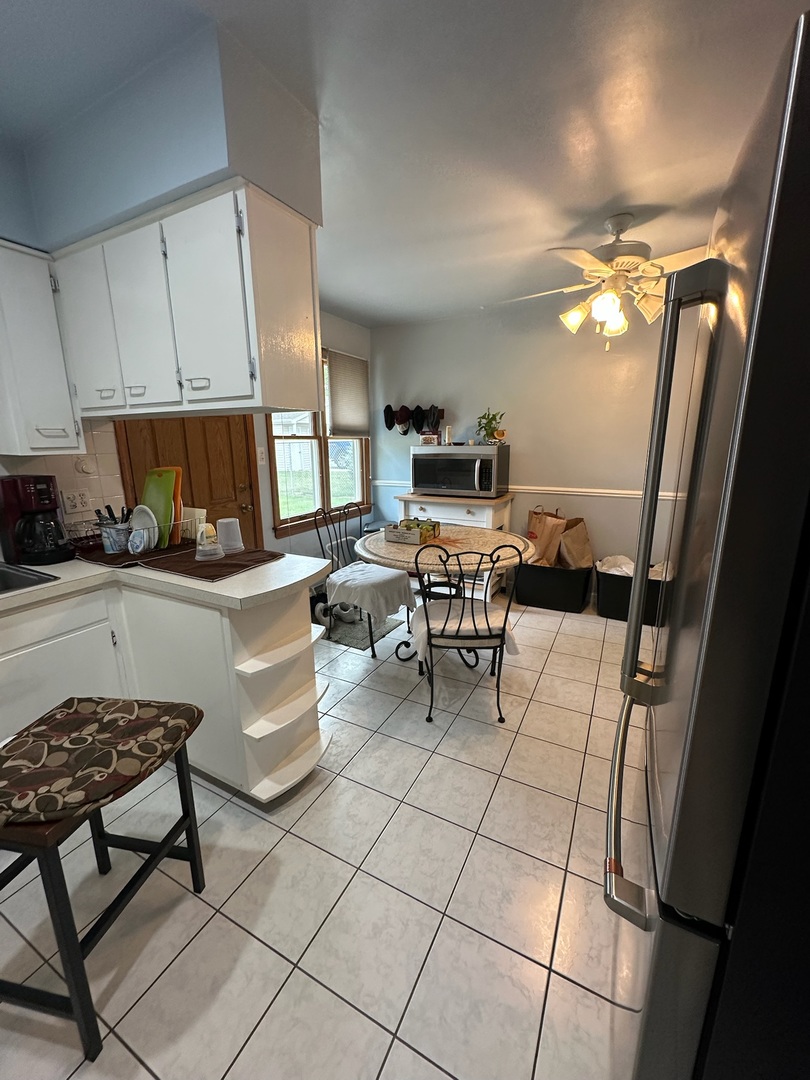 17871 Locust Street Lansing, IL 60438 - Photo 16 of 25 a kitchen with granite countertop a sink a stove a table and chairs