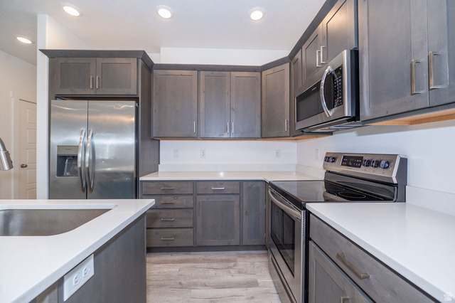 46 West 460 Smithfield, UT 84335 - Photo 11 of 31 Kitchen featuring dark wood-finish cabinetry, white solid surface countertops, stainless steel appliances, and recessed ceiling lighting