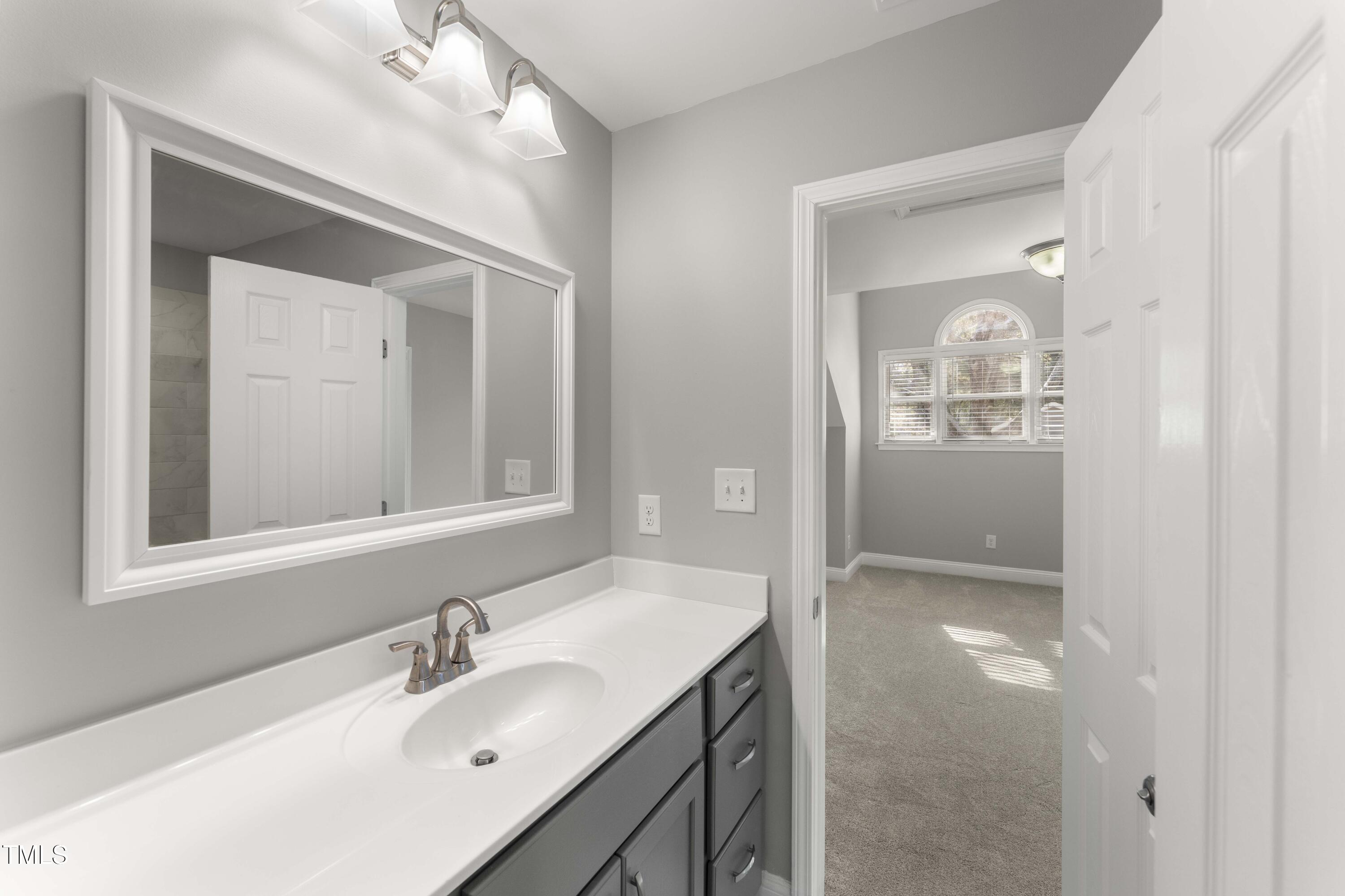 1426 Quarter Point Raleigh, NC 27615 - Photo 34 of 64 a bathroom with a sink a vanity a mirror and a shower