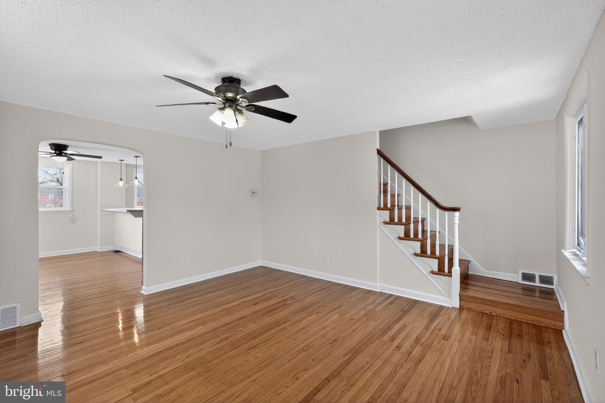 1311 Spring Street Sharon Hill, PA 19079 - Photo 3 of 21 a view of an empty room with wooden floor and a ceiling fan