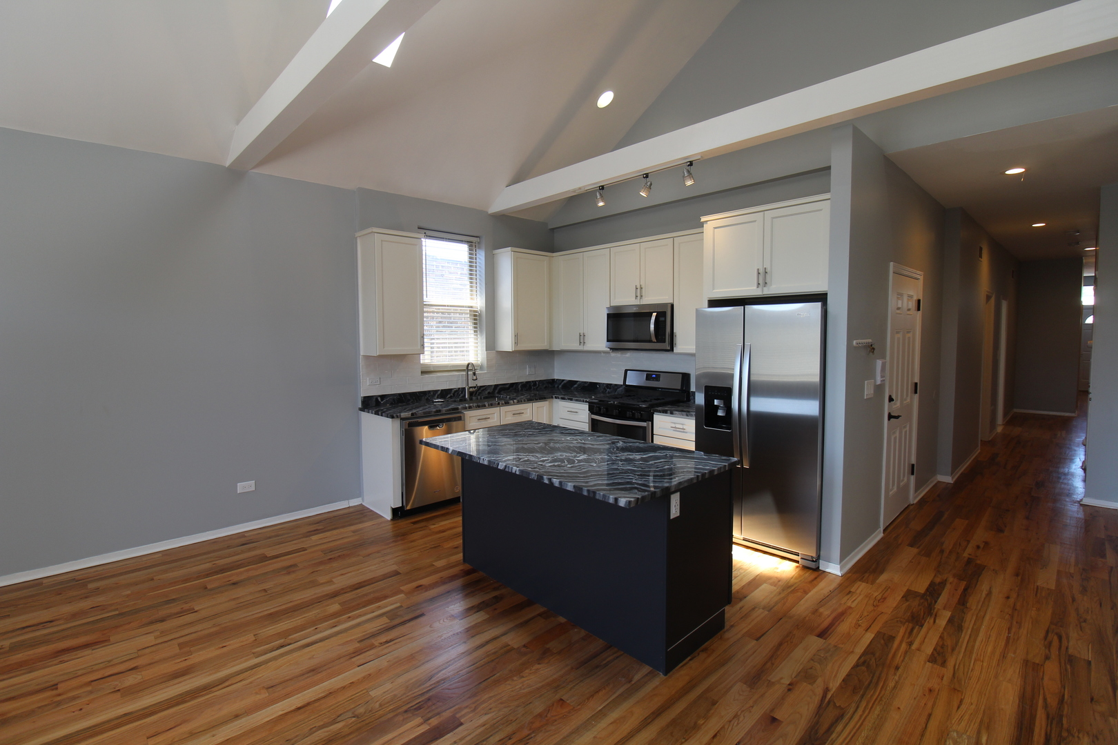 2054 West Division Street, Unit 3 Chicago, IL 60622 - Photo 4 of 15 a large kitchen with stainless steel appliances granite countertop a stove a refrigerator and a microwave