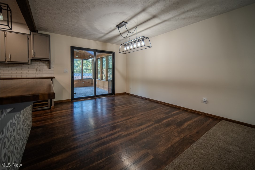 3459 Laubert Road Atwater, OH 44201 - Photo 10 of 39 Unfurnished dining area featuring dark wood-type flooring and a textured ceiling