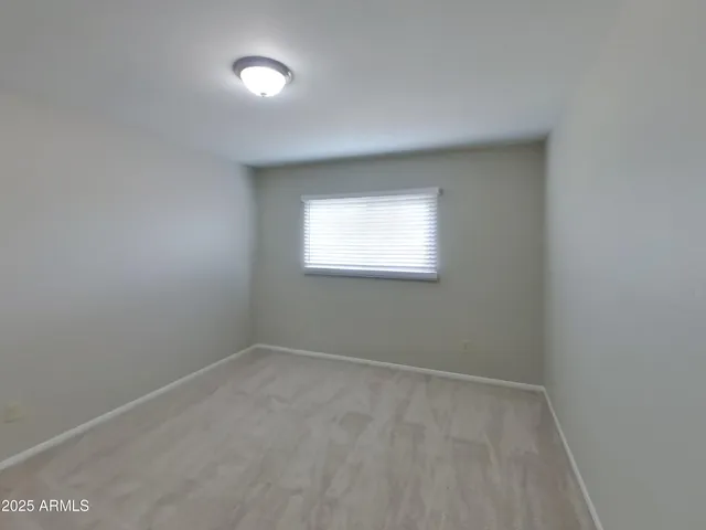 an empty room with closet and windows