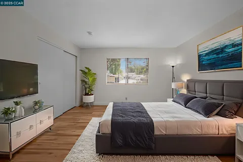 a bedroom with a large bed and a flat screen tv