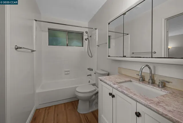 a bathroom with a granite countertop sink toilet and shower