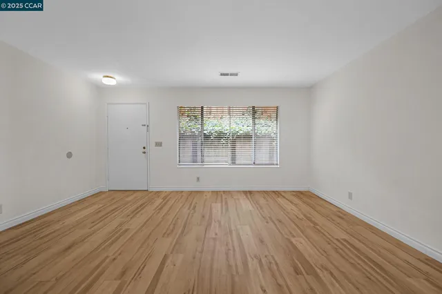 wooden floor in an empty room with a window