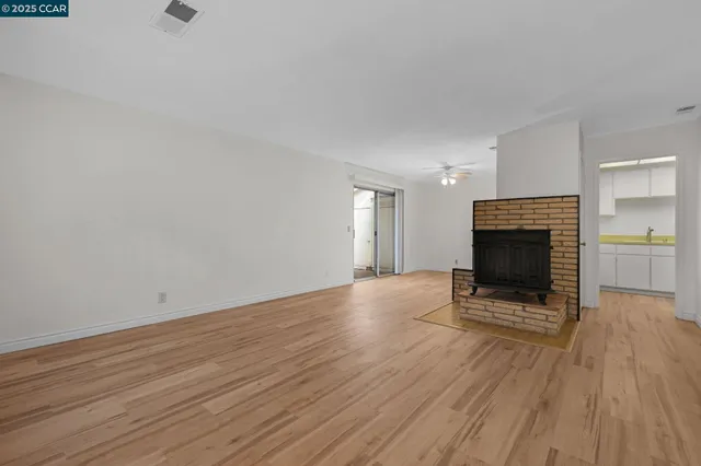 a view of a livingroom with wooden floor and a fireplace
