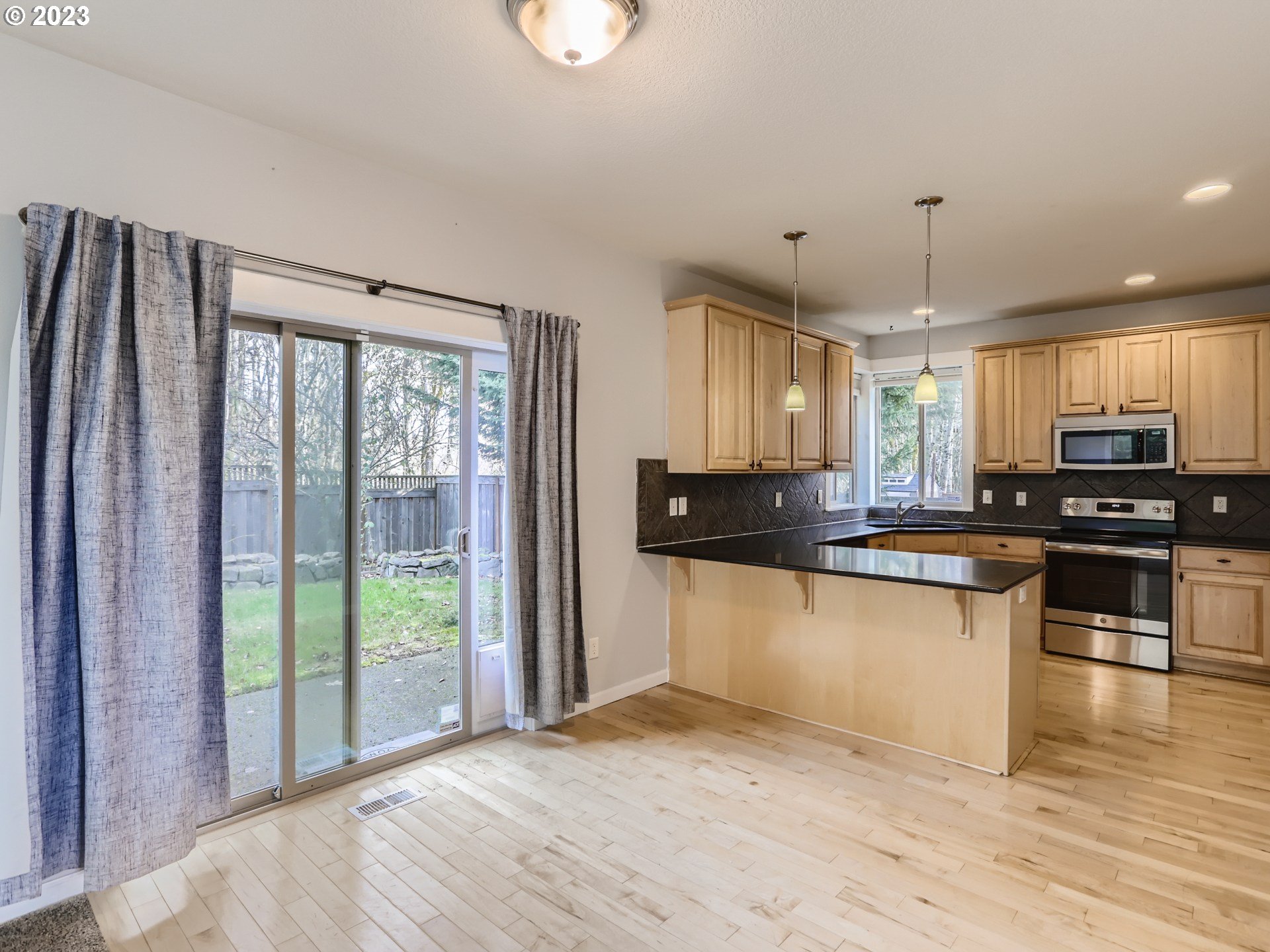 14505 Southeast Clatsop Street Portland, OR 97236 - Photo 7 of 27 a kitchen with stainless steel appliances granite countertop a refrigerator a sink dishwasher a stove and white countertops with wooden floor