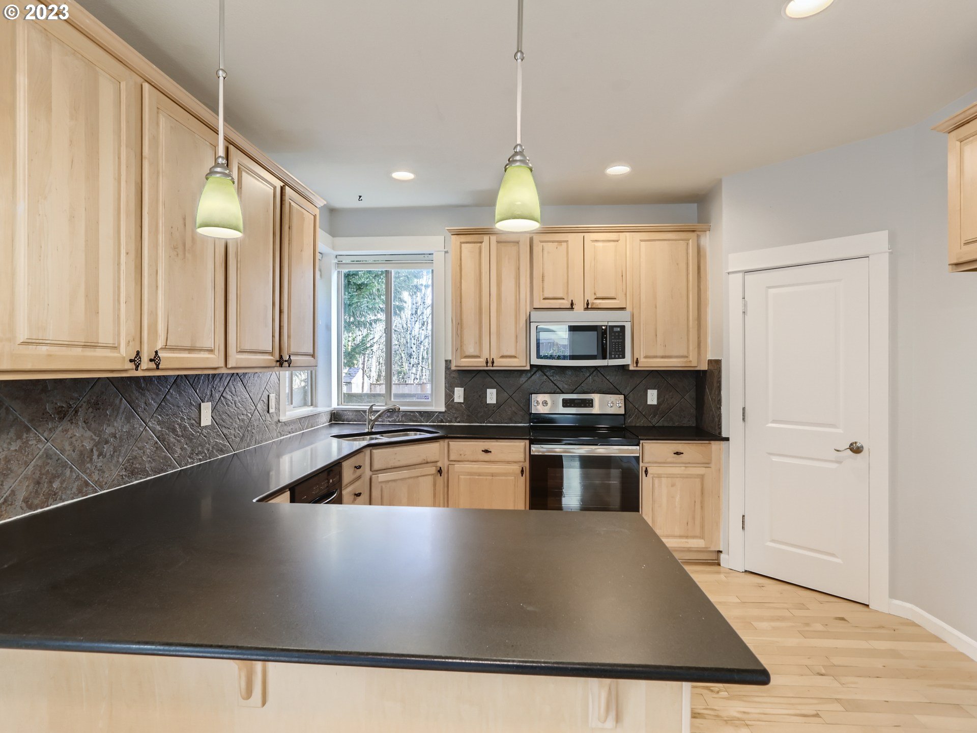 14505 Southeast Clatsop Street Portland, OR 97236 - Photo 8 of 27 a kitchen with stainless steel appliances granite countertop a stove a sink and a microwave