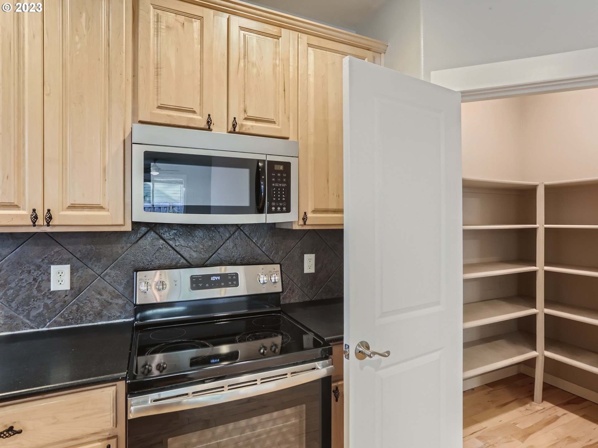 14505 Southeast Clatsop Street Portland, OR 97236 - Photo 9 of 27 a kitchen with granite countertop a stove microwave and cabinets