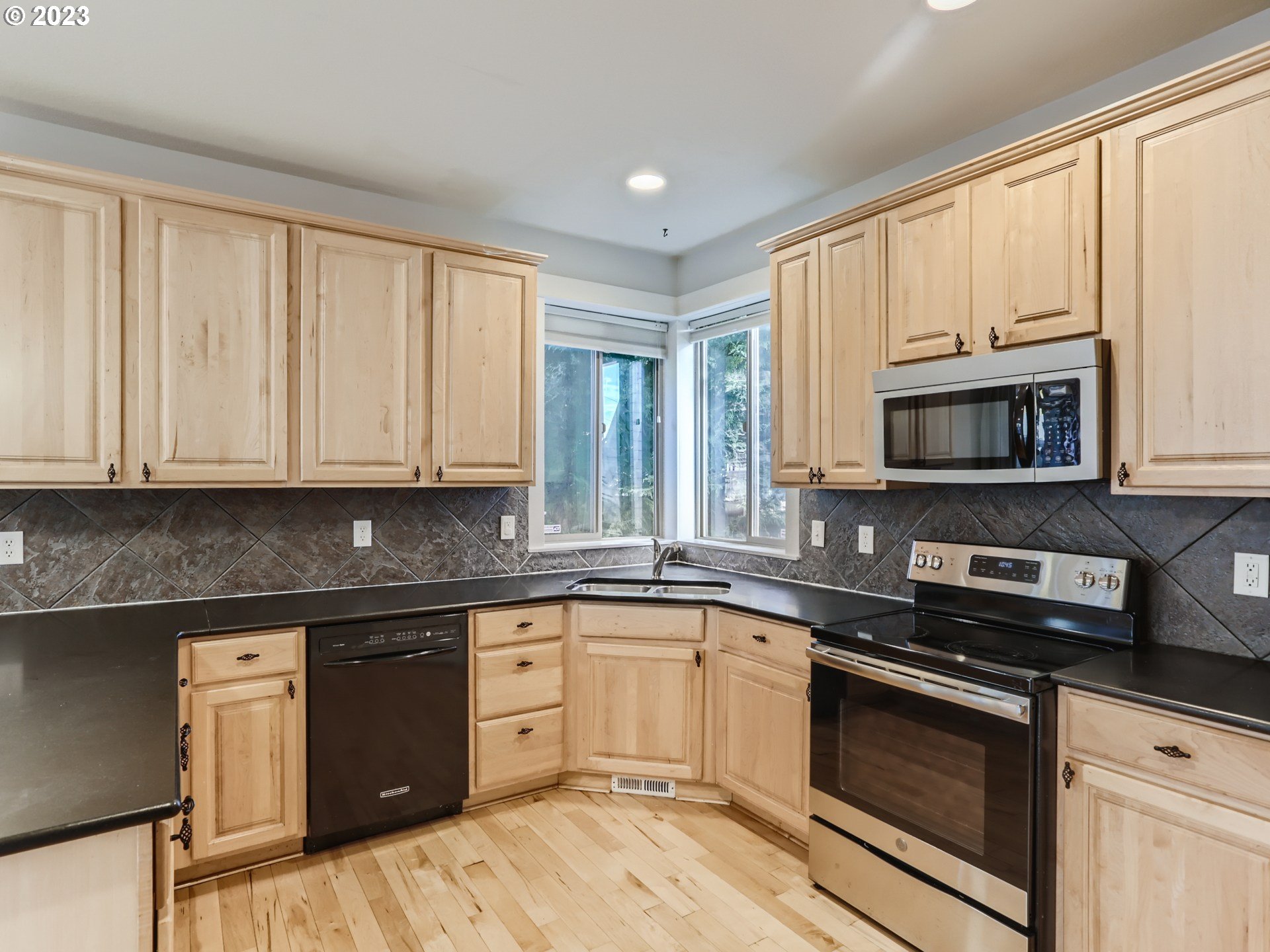 14505 Southeast Clatsop Street Portland, OR 97236 - Photo 10 of 27 a kitchen with stainless steel appliances granite countertop white cabinets granite counter tops and a window