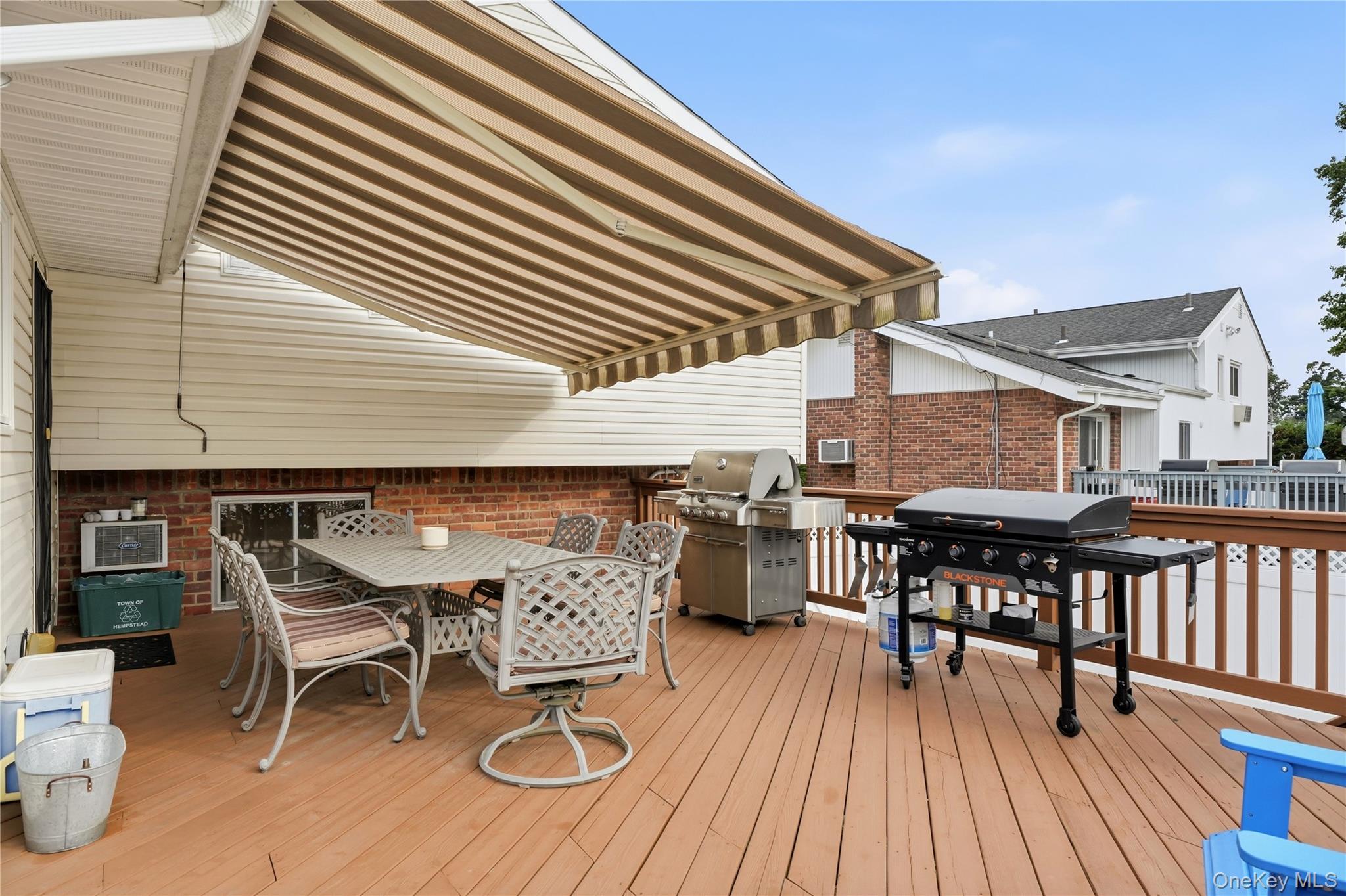 1853 Decatur Avenue Merrick, NY 11566 - Photo 39 of 43 a view of a roof deck with table and chairs floor to ceiling window with wooden floor