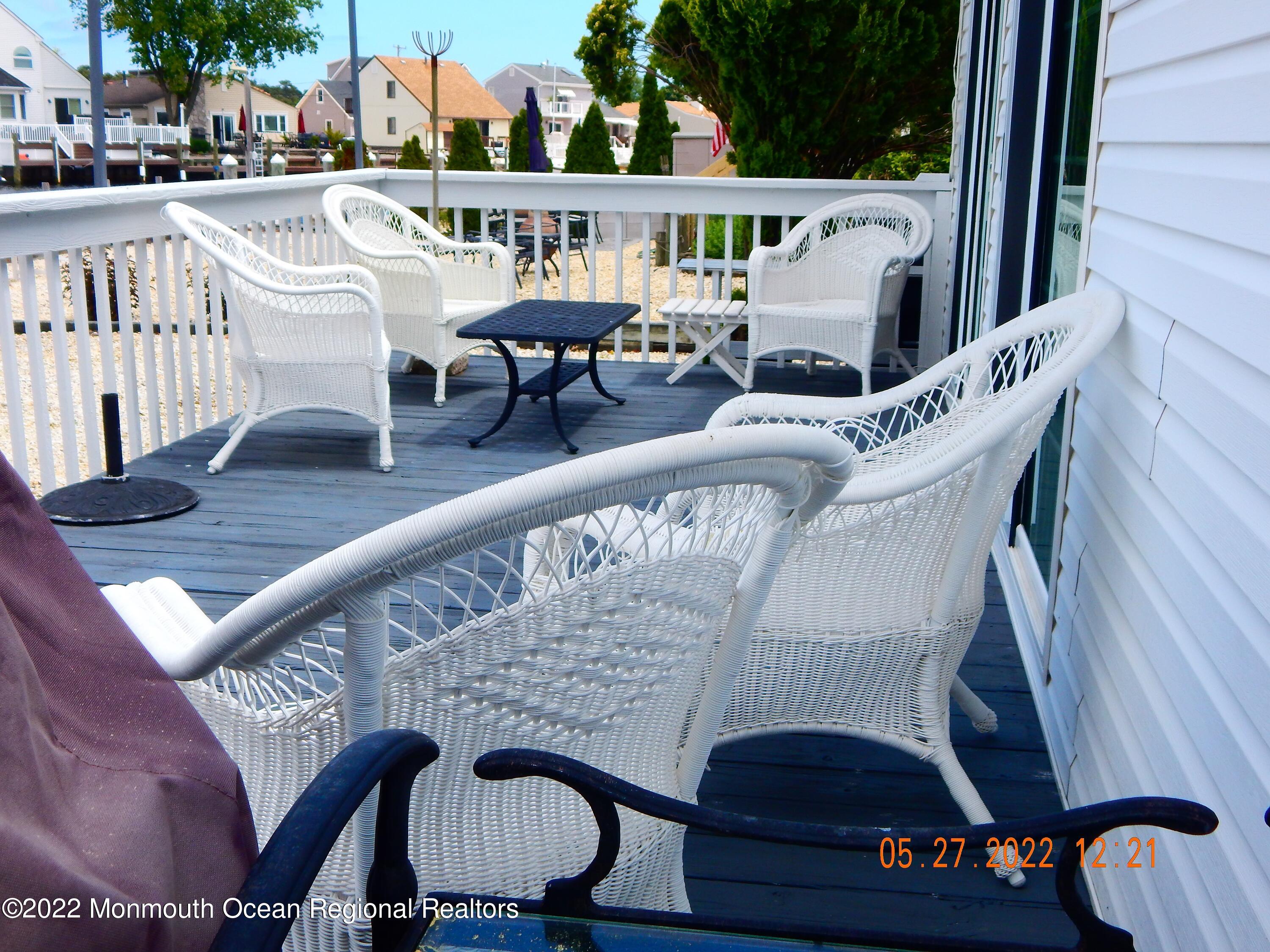 27 Club House Road Brick, NJ 08723 - Photo 27 of 31 a balcony with wooden floor table and chairs