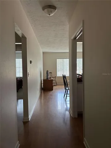a view of a hallway with wooden floor windows and livingroom