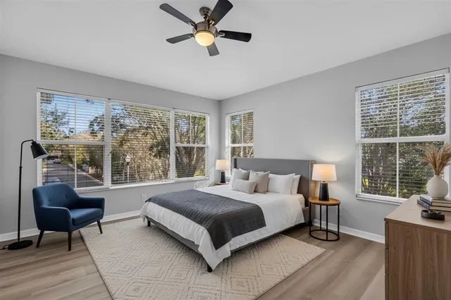 a bedroom with a bed a couch and a large window