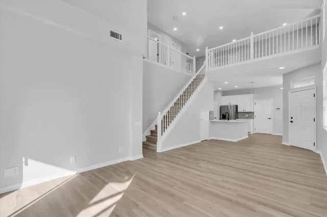 a view of empty room with wooden floor