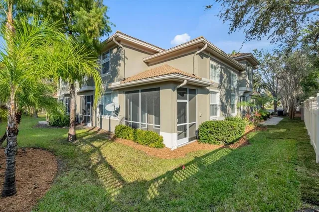 a view of a white house next to a yard with big trees