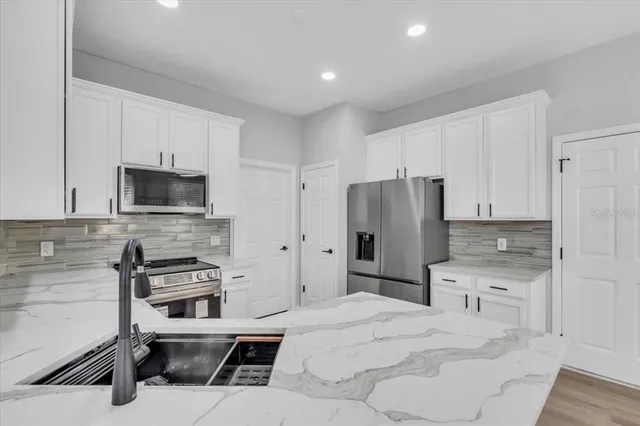 a kitchen with stainless steel appliances a refrigerator stove and microwave