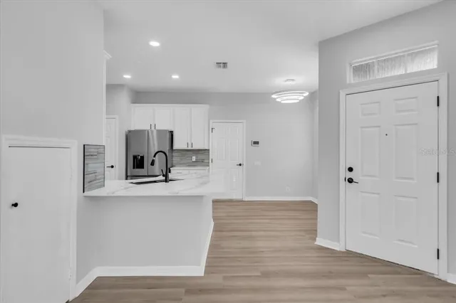 a view of kitchen with cabinets stainless steel appliances and wooden floor