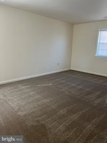 a view of kitchen and empty room with wooden floor