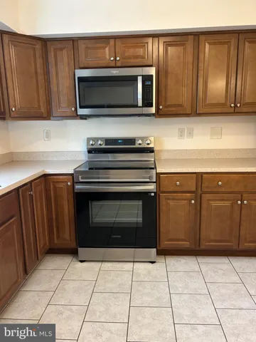 a kitchen with stainless steel appliances a stove a sink a microwave and cabinets