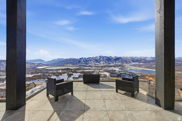 2002 East Outlaw Road Kamas, UT 84036 - Photo 16 of 65 Expansive outdoor terrace featuring large format tile flooring, a glass railing system, and a mountain and lake backdrop