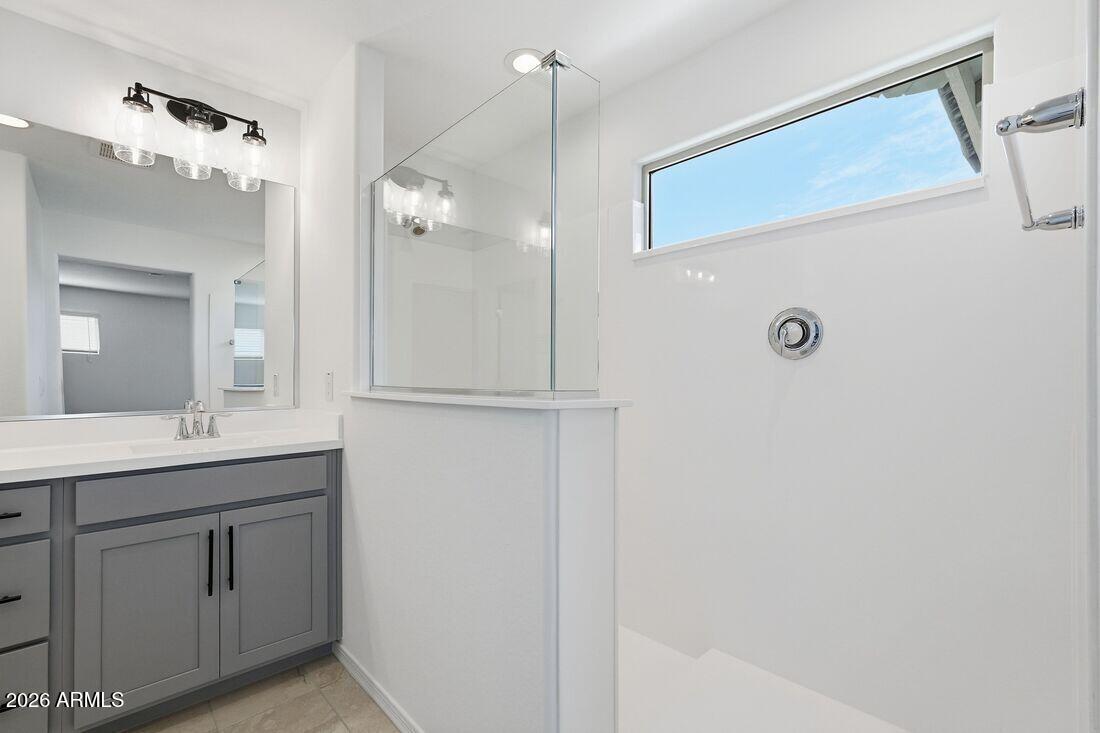 10048 West Piccadilly Road Avondale, AZ 85392 - Photo 20 of 49 a bathroom with a double vanity sink a mirror and a shower
