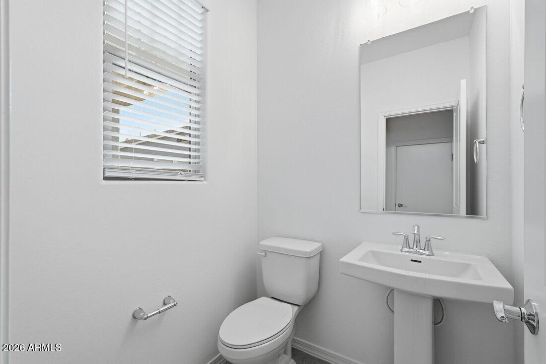 10048 West Piccadilly Road Avondale, AZ 85392 - Photo 26 of 49 a bathroom with a toilet a sink and mirror
