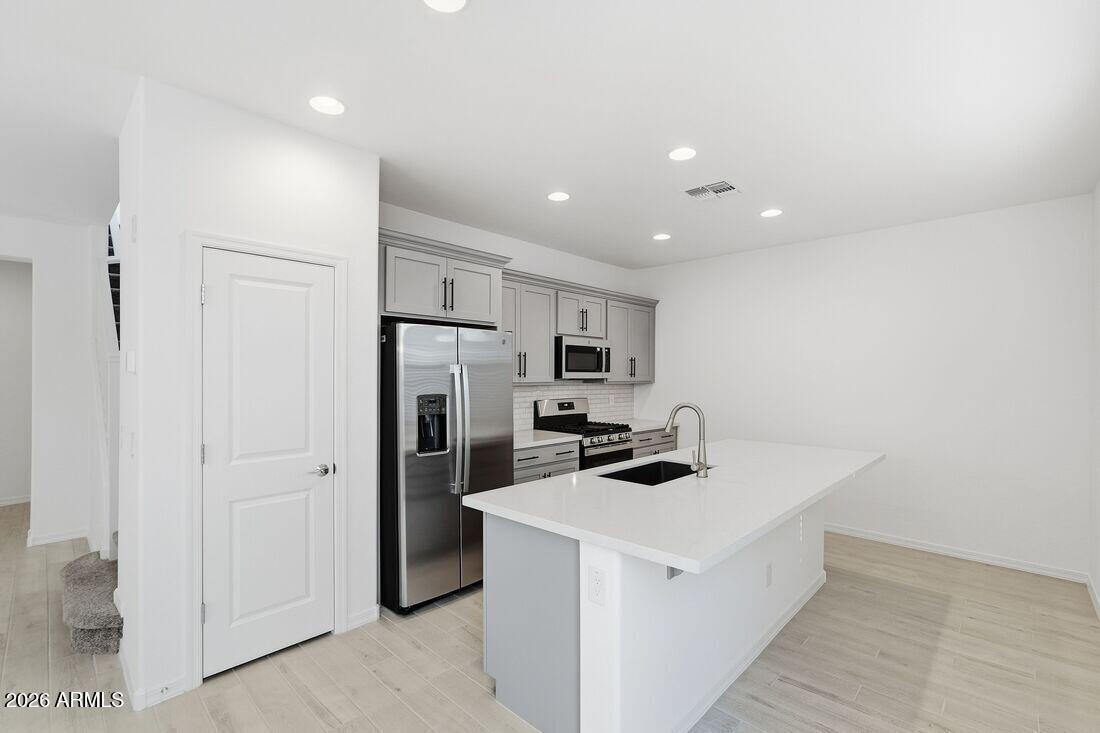 10048 West Piccadilly Road Avondale, AZ 85392 - Photo 6 of 49 a kitchen that has a refrigerator a stove and white cabinets