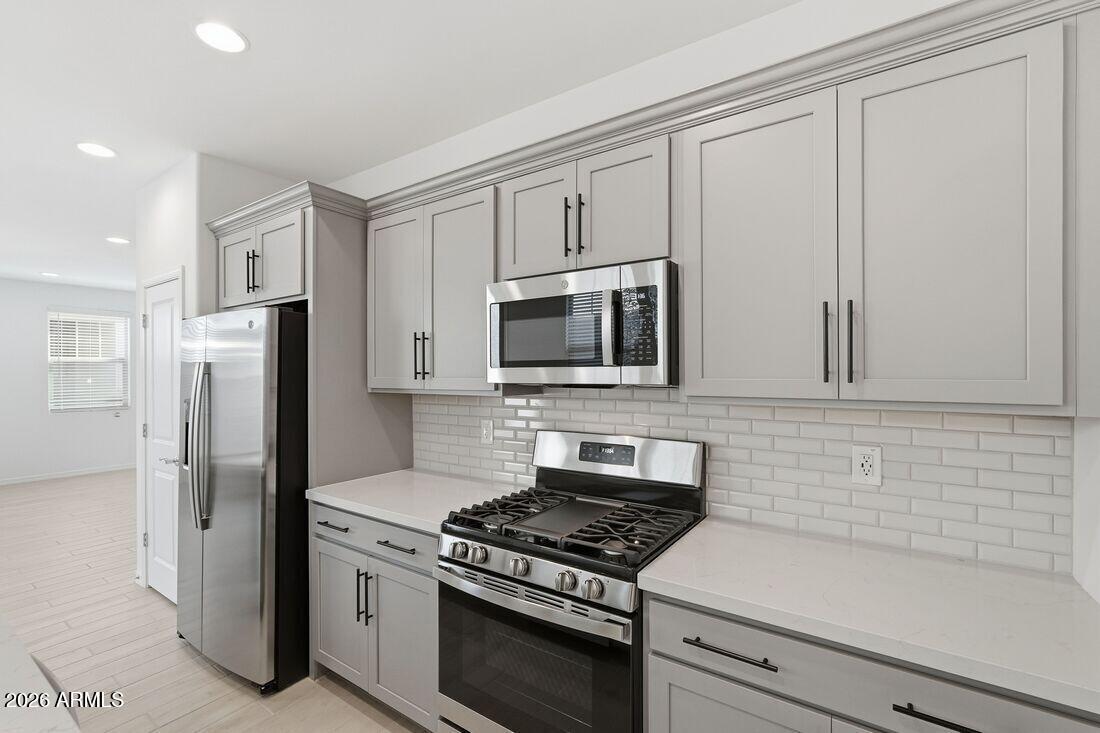 10048 West Piccadilly Road Avondale, AZ 85392 - Photo 8 of 49 a kitchen with stainless steel appliances white cabinets and a stove top oven