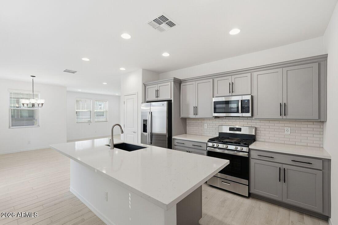 10048 West Piccadilly Road Avondale, AZ 85392 - Photo 9 of 49 a kitchen with stainless steel appliances kitchen island granite countertop a sink stove and refrigerator