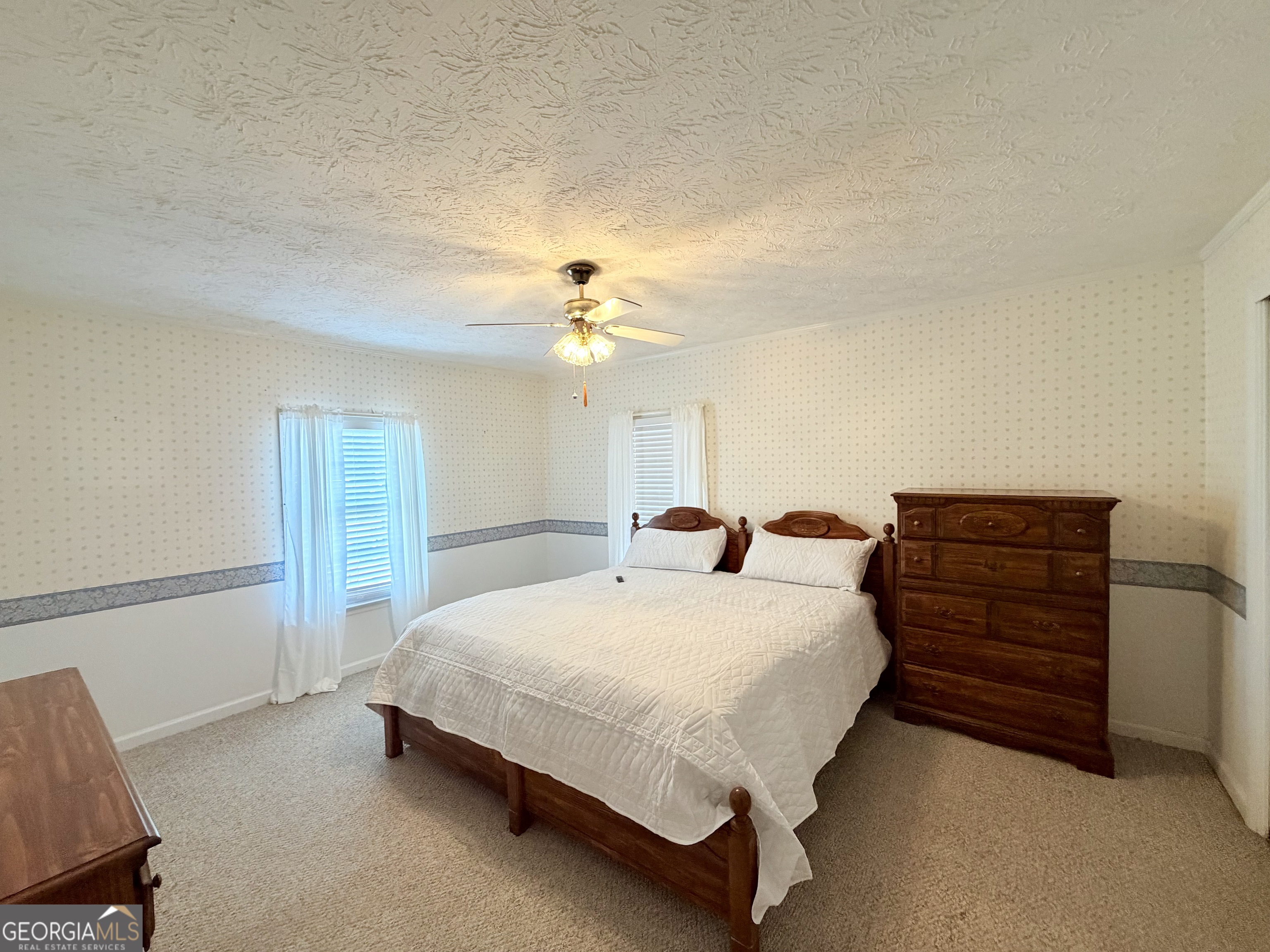17 2nd Street McRae-Helena, GA 31037 - Photo 23 of 51 a bedroom with a bed a chandelier and dresser