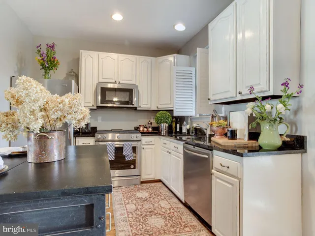 a kitchen with stainless steel appliances granite countertop a stove refrigerator sink and cabinets