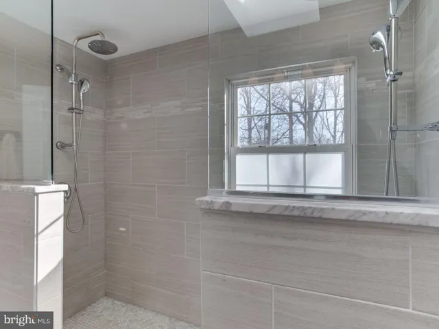 a bathroom with a window and a shower