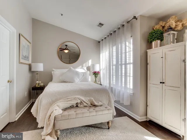 a bedroom with a white bed and a large mirror