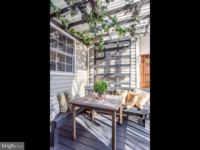 a view of a deck with table and chairs with wooden floor and plants