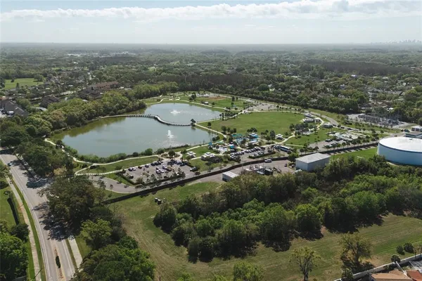 an aerial view of residential houses with outdoor space and trees
