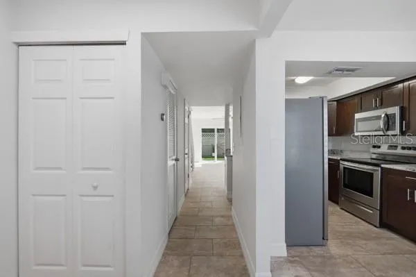 a view of a hallway with a livingroom and a bathroom