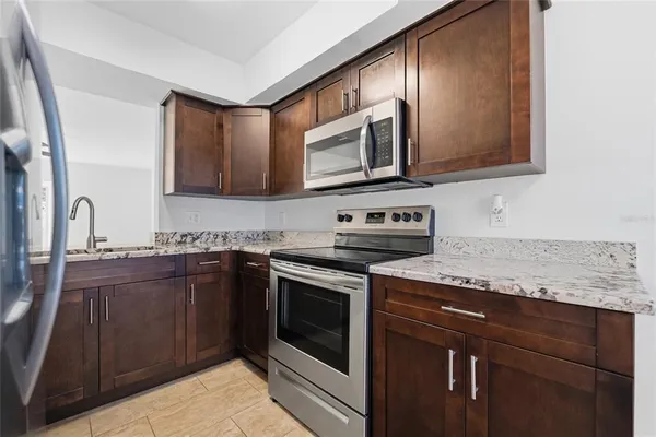 a kitchen with stainless steel appliances granite countertop a sink stove and microwave