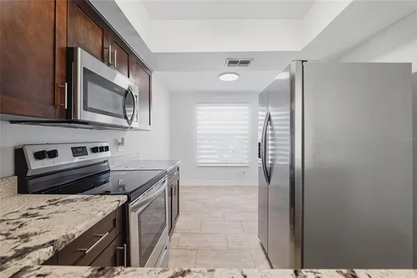a kitchen with stainless steel appliances granite countertop a stove and a refrigerator