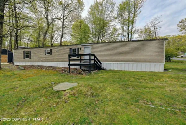 a view of a backyard with wooden fence and a bench