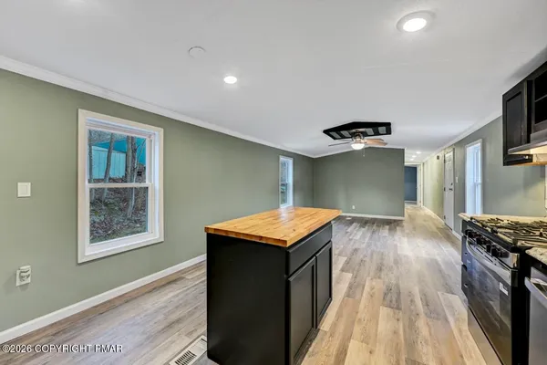 a kitchen with kitchen island granite countertop a sink cabinets and stainless steel appliances